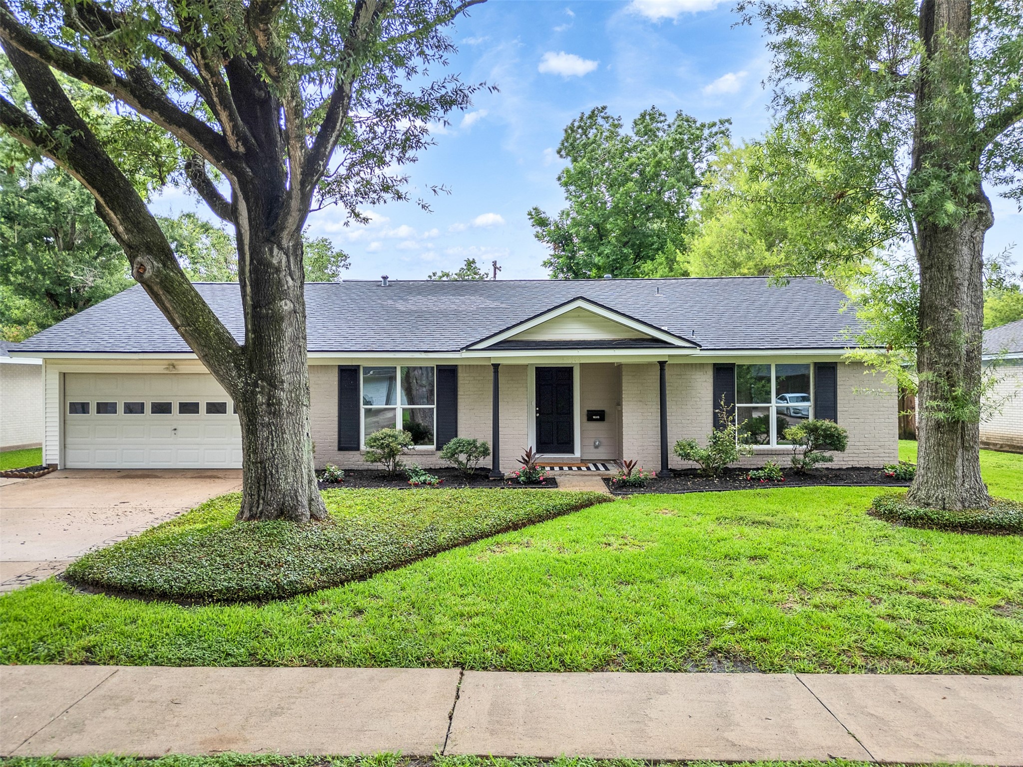 Welcome to 10315 Winding Trail, a charming home with inviting curb appeal, featuring a classic facade framed by mature trees and lush greenery, perfect for your next chapter.