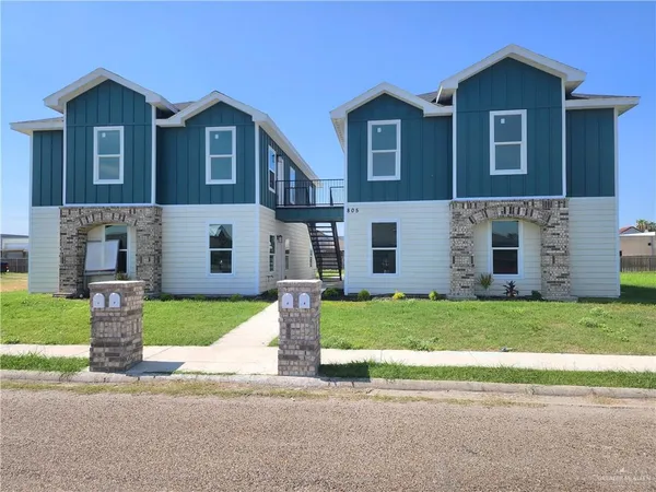 a front view of a house with a garden and yard