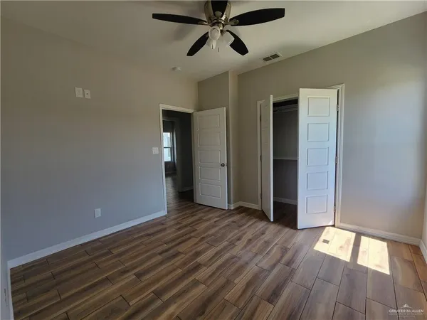 a view of empty room with wooden floor