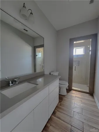 a bathroom with a sink a toilet and shower