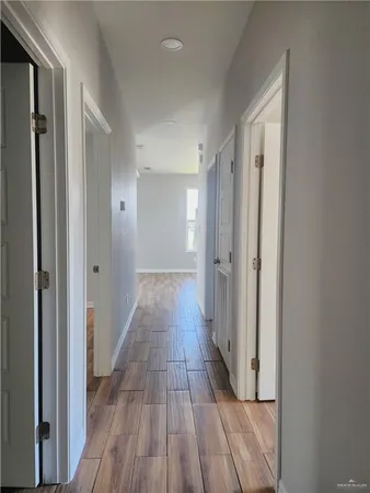 a view of a hallway with wooden floor