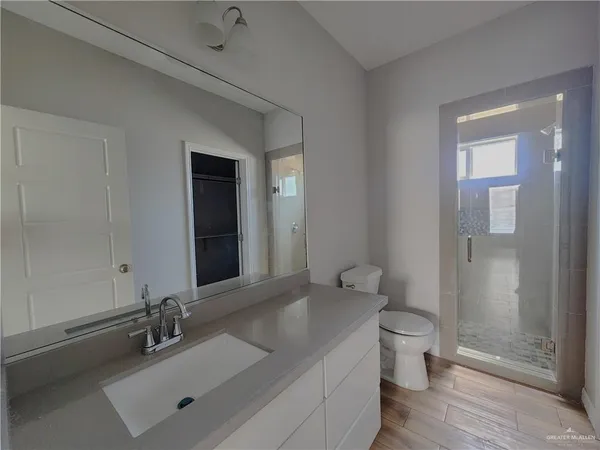 a bathroom with a sink a toilet and shower