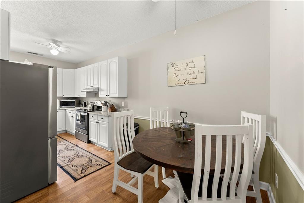 2832 B B Wilson Road Commerce, GA 30529 - Photo 48 of 96 a kitchen with granite countertop a refrigerator a stove a sink dishwasher and a dining table with wooden floor