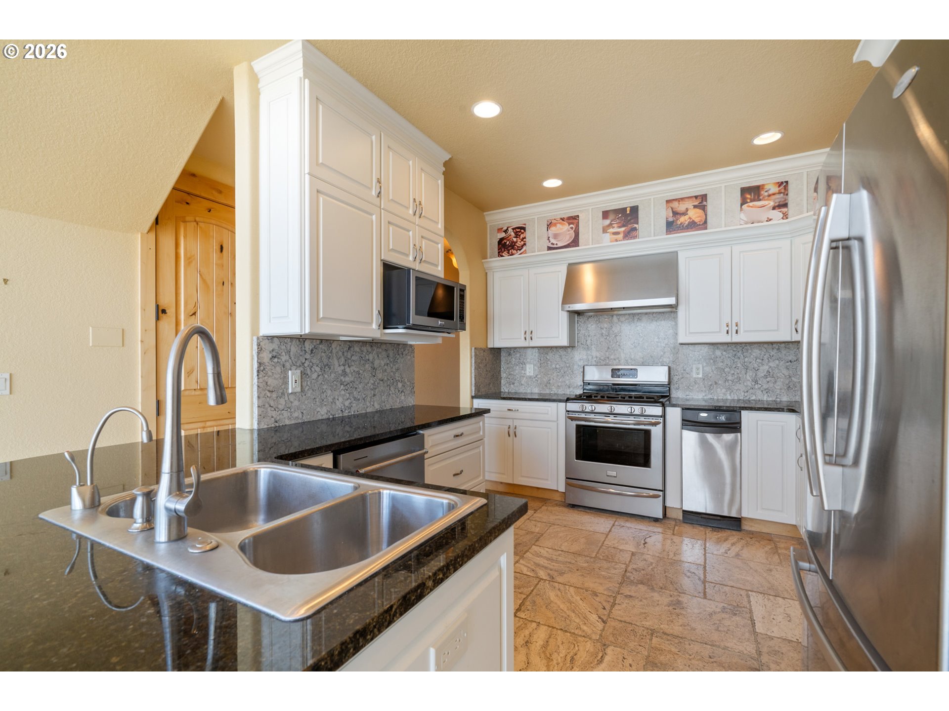 367 South Longview Loop Rockaway Beach, OR 97136 - Photo 11 of 48 a kitchen with kitchen island granite countertop a sink stove and refrigerator