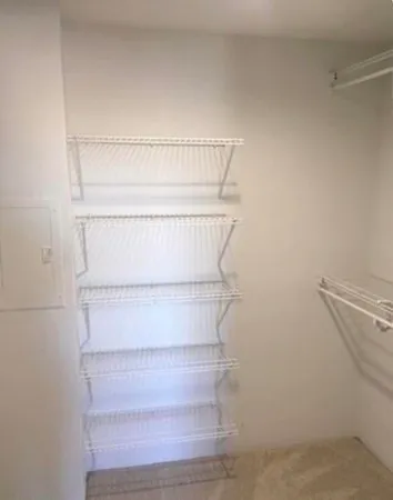 a view of walk in closet with empty racks