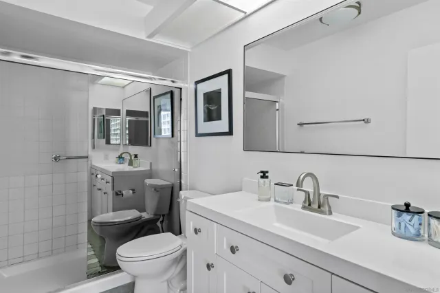 a bathroom with a toilet sink double vanity and mirror