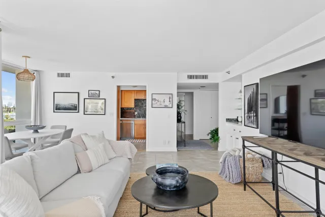 a living room with furniture and a dining table with wooden floor