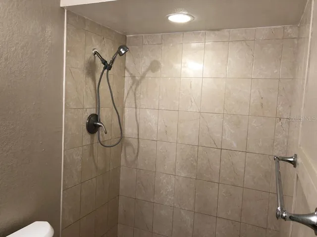 a bathroom with a granite countertop toilet and a sink