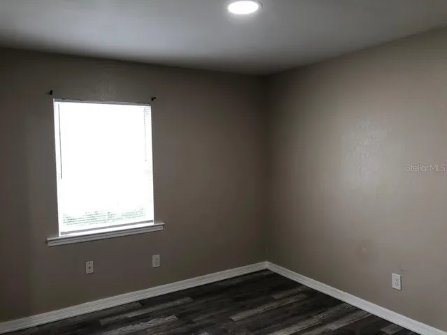 an empty room with windows and closet