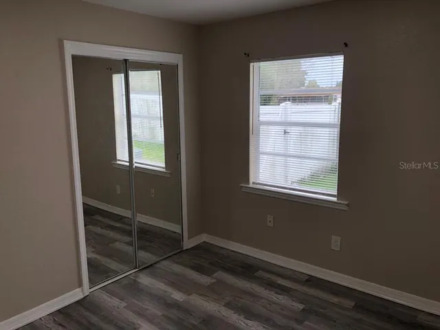 an empty room with wooden floor and closet