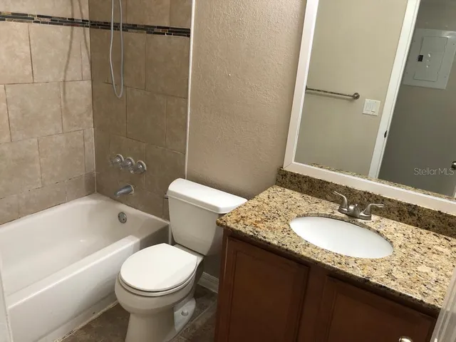 a bathroom with a granite countertop sink toilet and shower
