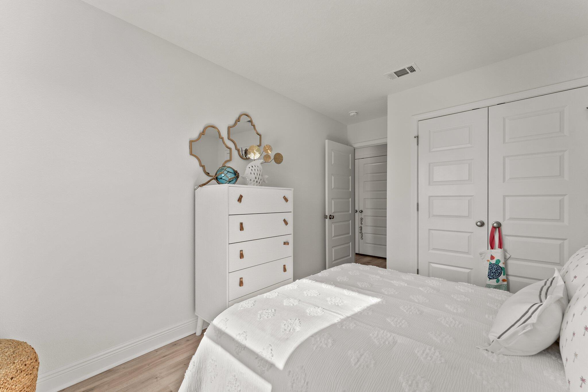 2 Renea Cove, Unit LOT 009 Destin, FL 32541 - Photo 29 of 30 a bedroom with a bed and a chandelier