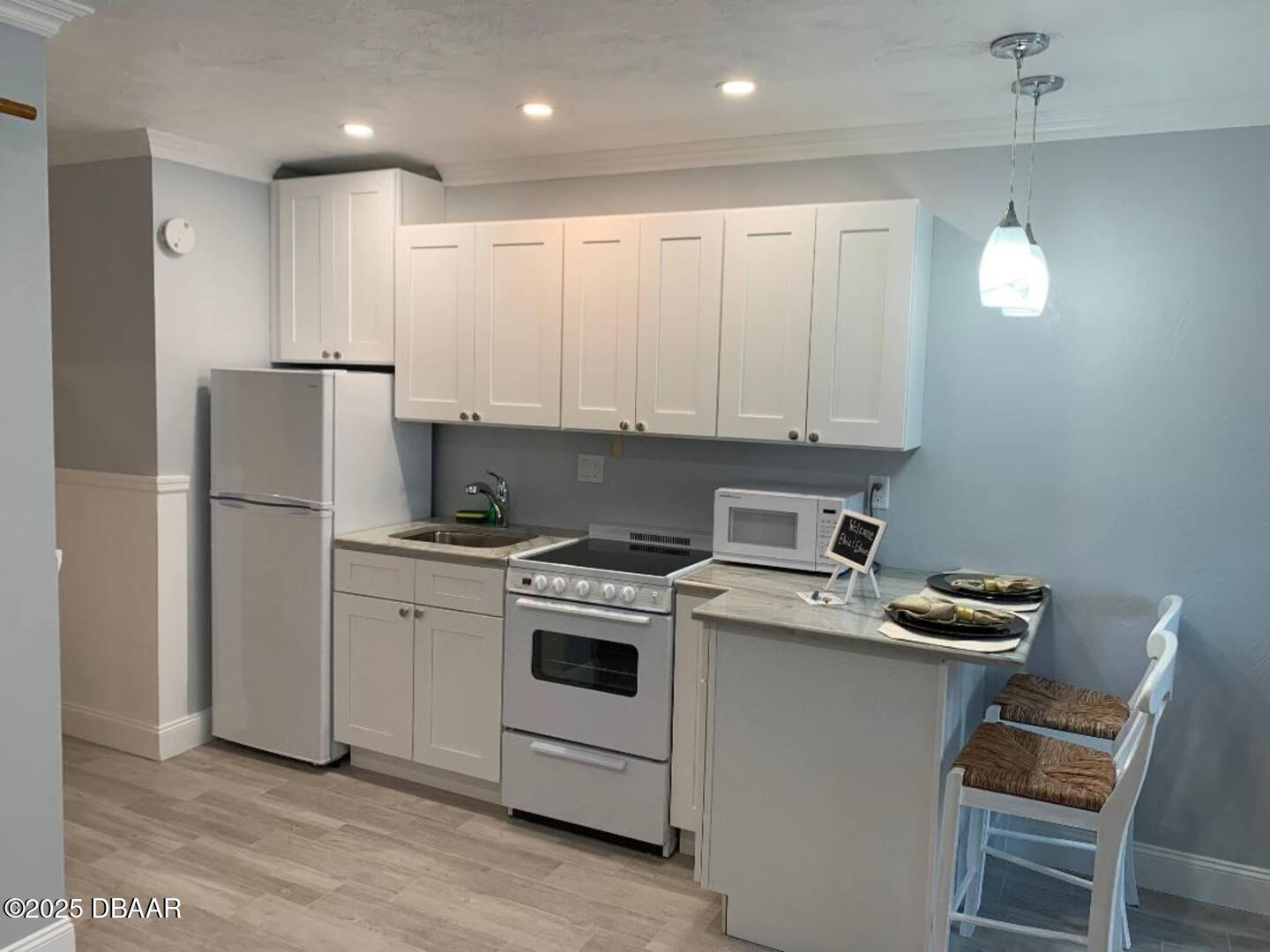 3727 South Atlantic Avenue, Unit 4030 Daytona Beach, FL 32118 - Photo 3 of 8 a kitchen with a stove sink and refrigerator
