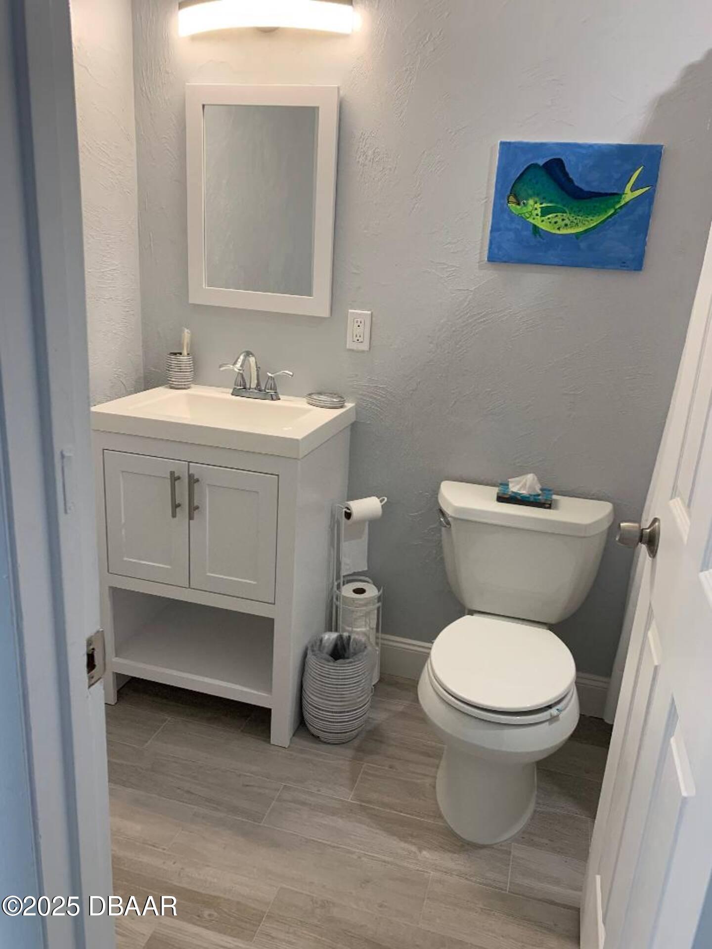 3727 South Atlantic Avenue, Unit 4030 Daytona Beach, FL 32118 - Photo 5 of 8 a bathroom with a toilet sink and mirror