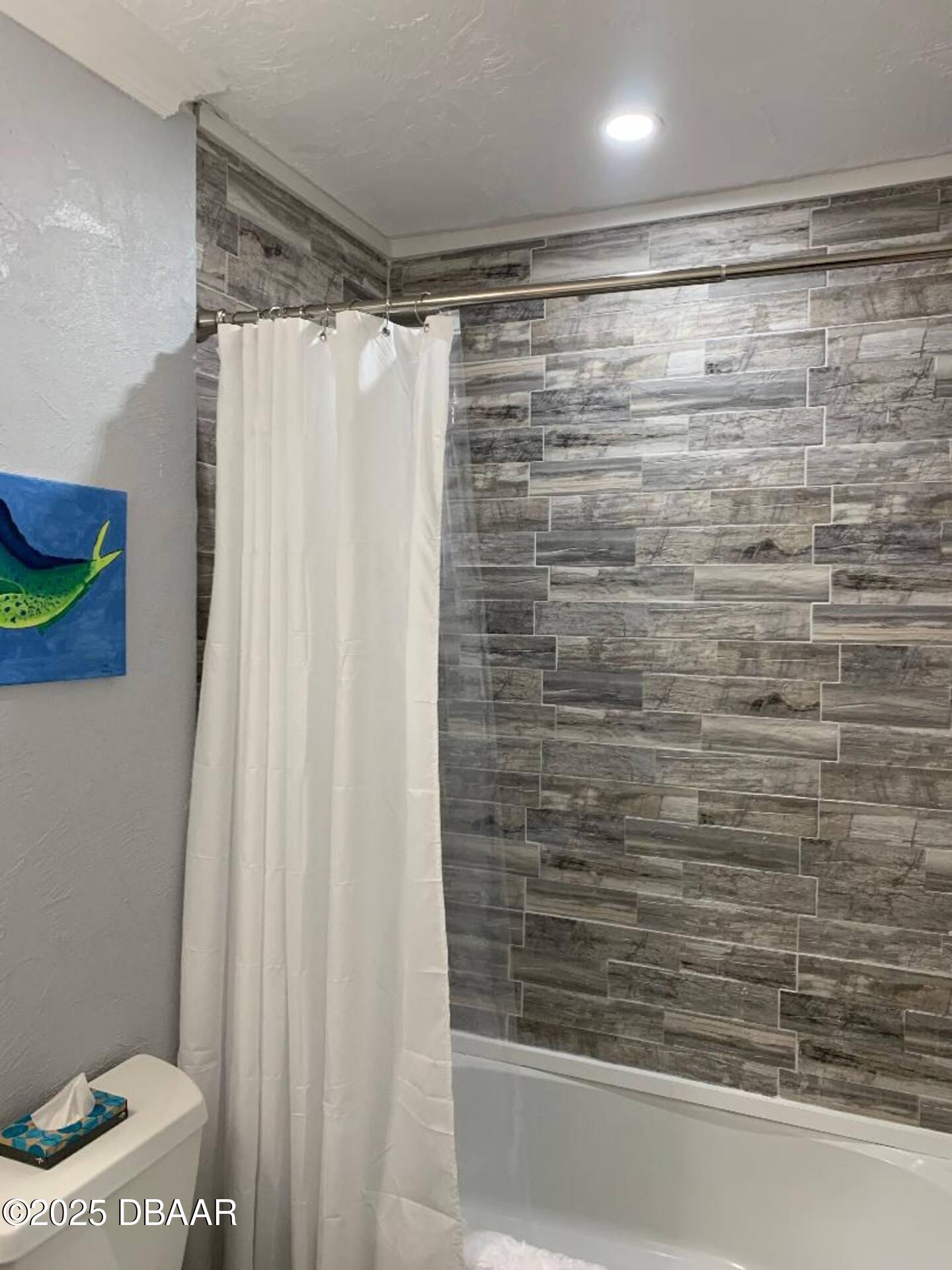 3727 South Atlantic Avenue, Unit 4030 Daytona Beach, FL 32118 - Photo 6 of 8 a bathroom with a shower curtain and a toilet