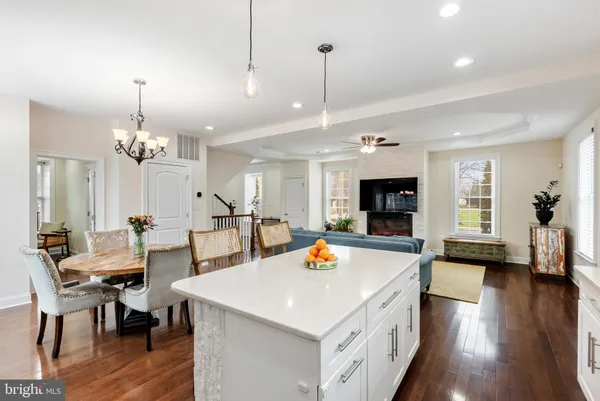 a view of a dining room and livingroom with furniture wooden floor a chandelier