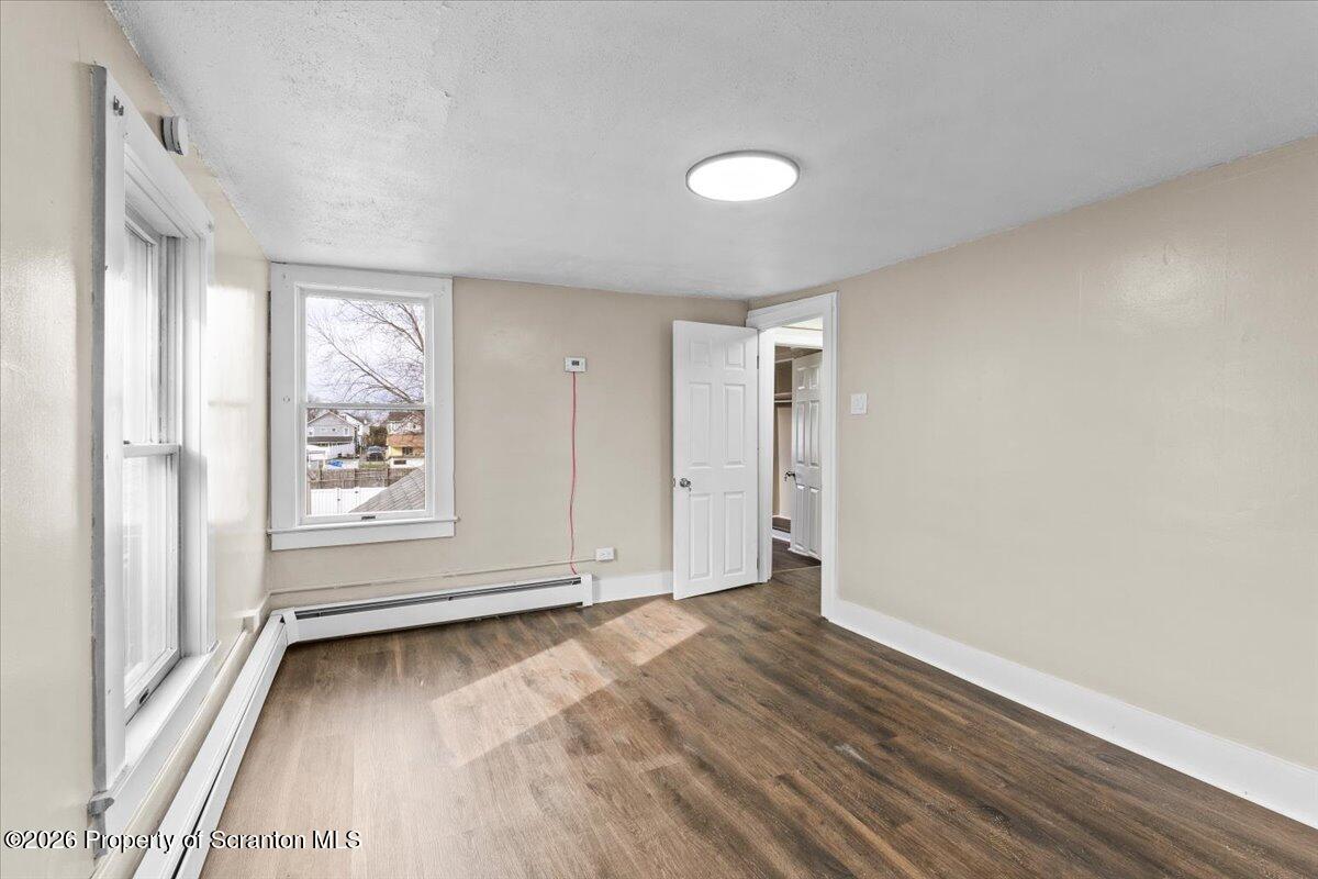132 Penn Avenue Exeter, PA 18643 - Photo 17 of 44 an empty room with wooden floor and windows