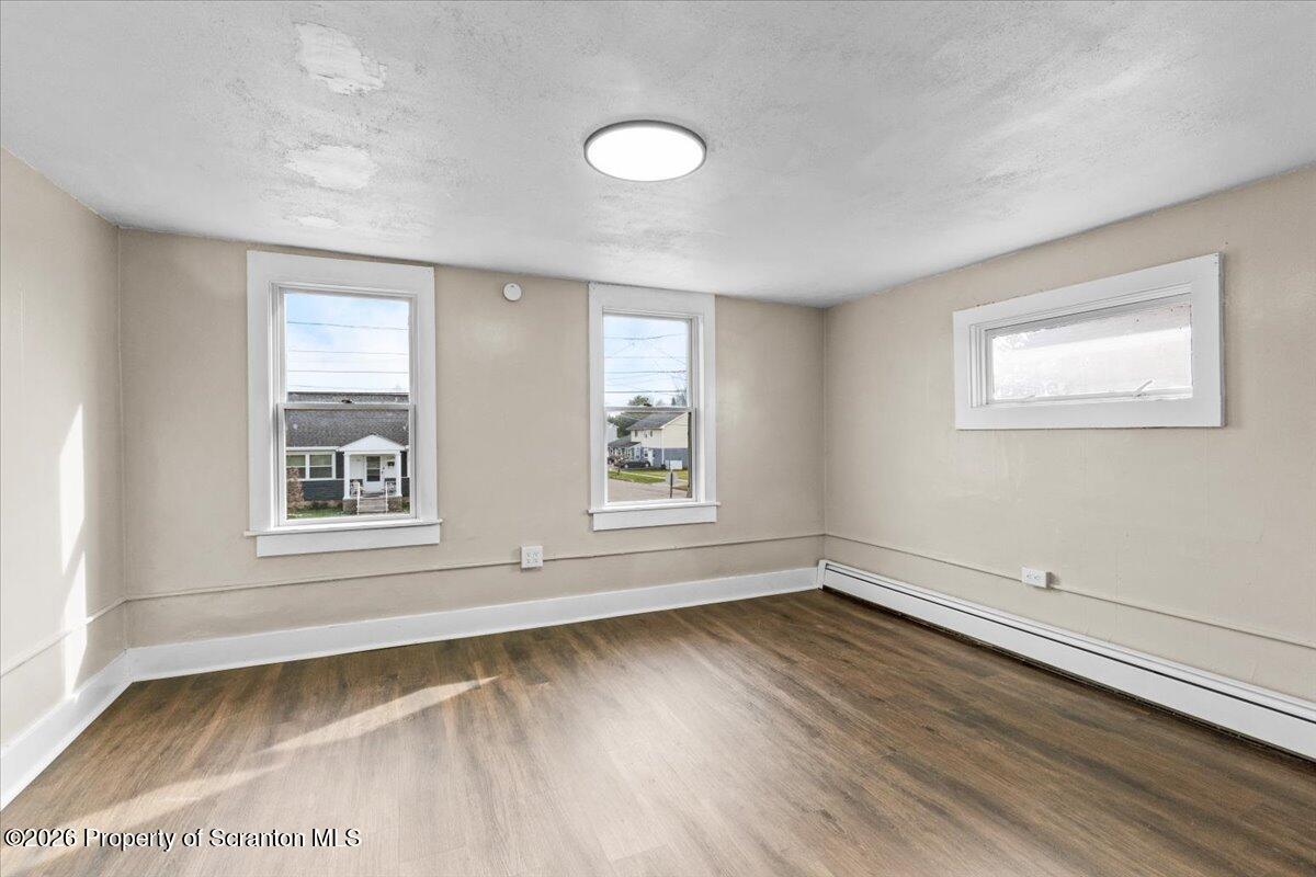132 Penn Avenue Exeter, PA 18643 - Photo 18 of 44 an empty room with wooden floor and windows