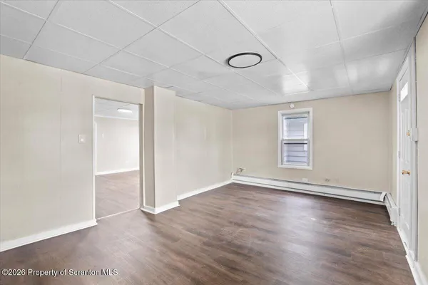 wooden floor in an empty room with a window