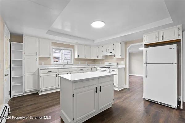 a kitchen with white cabinets and white appliances