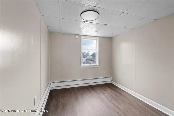 a view of empty room with wooden floor