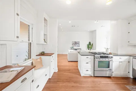 a kitchen with stainless steel appliances white cabinets and wooden floors
