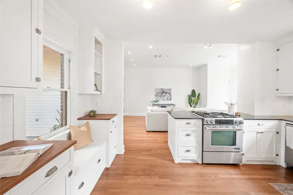 a kitchen with stainless steel appliances white cabinets and wooden floors