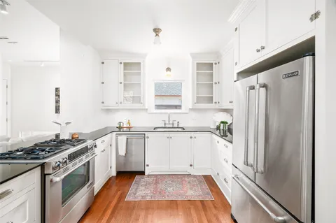 a kitchen with stainless steel appliances a stove a sink and a refrigerator