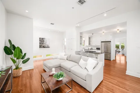 a living room with furniture and a wooden floor