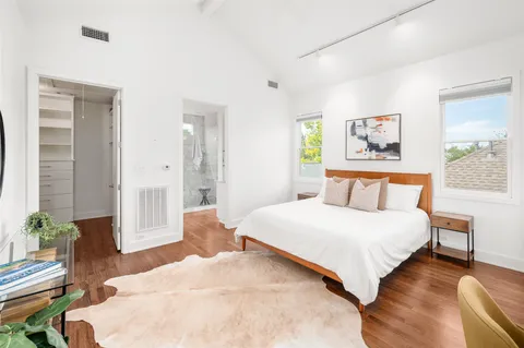 a bedroom with a bed and a painting on the wall