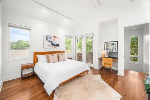 a bedroom with a large bed and a wooden floor