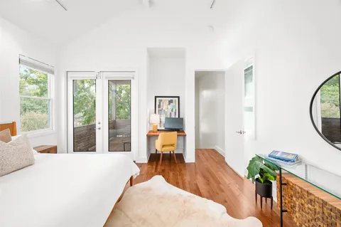 a spacious bedroom with a bed and large windows