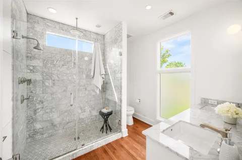 a bathroom with a granite countertop shower a sink and a mirror