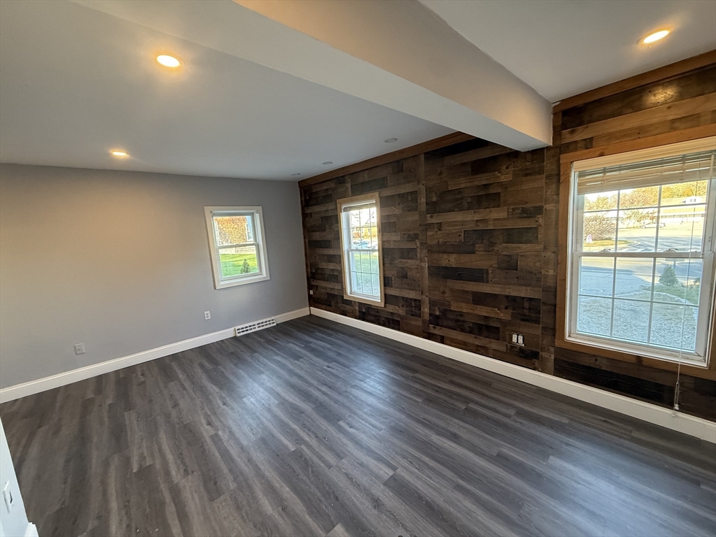 176 Court Street, Unit 1 Plymouth, MA 02360 - Photo 5 of 11 an empty room with wooden floor and windows