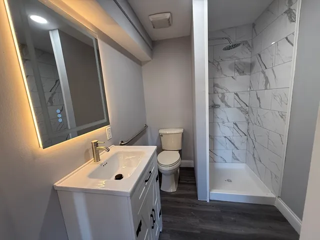 a bathroom with a sink a toilet and shower
