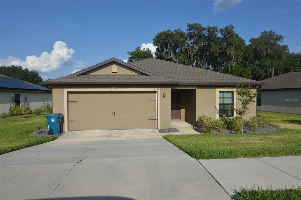6898 Redbay Drive Brooksville, FL 34602 - Photo 1 of 1 a front view of a house with garden