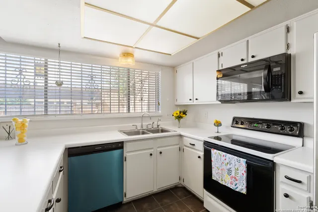 a kitchen with stainless steel appliances a sink a stove and cabinets