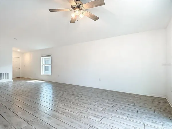 a view of an empty room and wooden floor