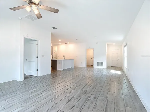 an empty room with a window and a fan