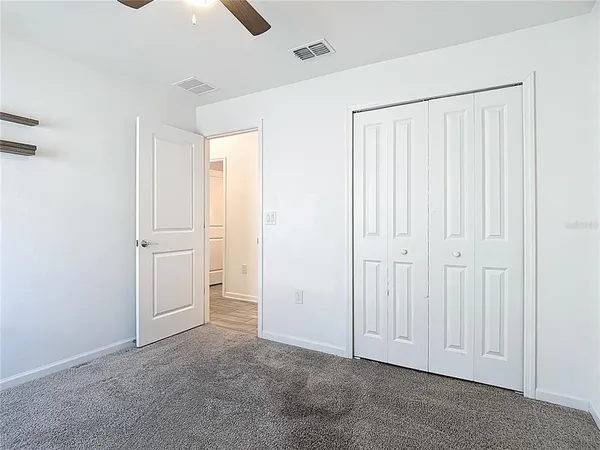 an empty room with chandelier fan
