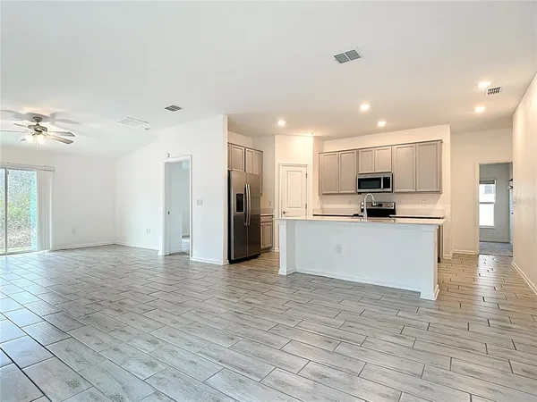 a view of kitchen with granite countertop cabinets and refrigerator
