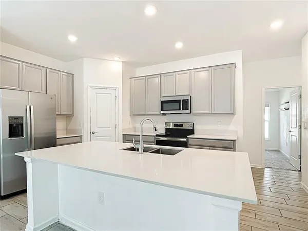 a kitchen with stainless steel appliances a refrigerator stove microwave and cabinets