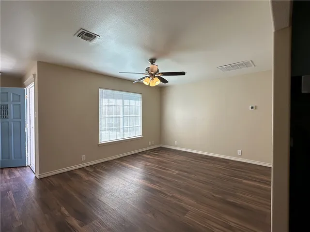 wooden floor in an empty room with a window