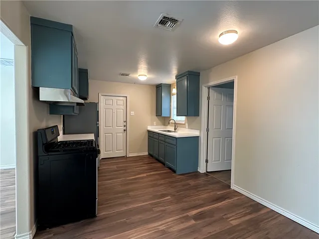 a kitchen with a refrigerator and a sink
