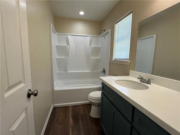a bathroom with a sink a toilet a tub and shower
