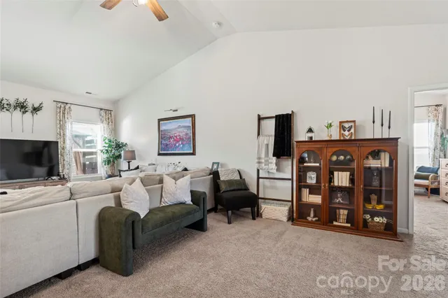 a large bed in a bedroom next to a window and a chandelier