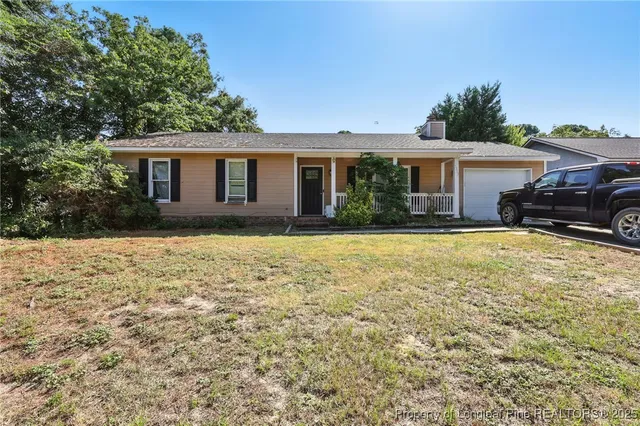 a front view of house with yard and trees around