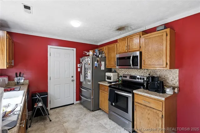 a kitchen with stainless steel appliances a stove a microwave a sink and cabinets