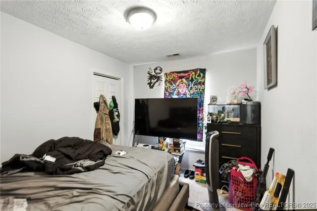 a bedroom with bed and a flat screen tv