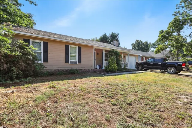 a front view of house with yard and trees around